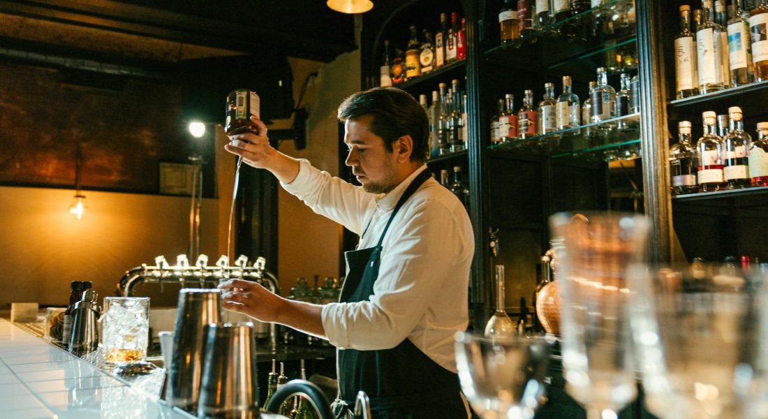 Bartender at local bar pouring a cocktail