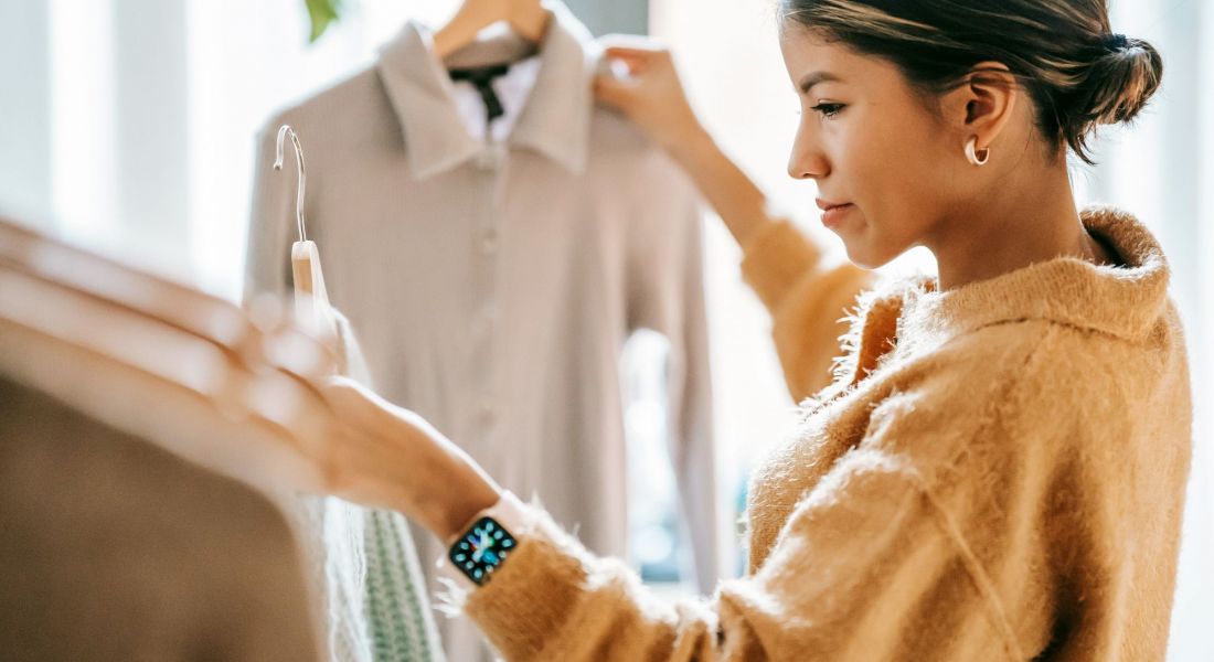 Woman shopping and picking out different dress shirts