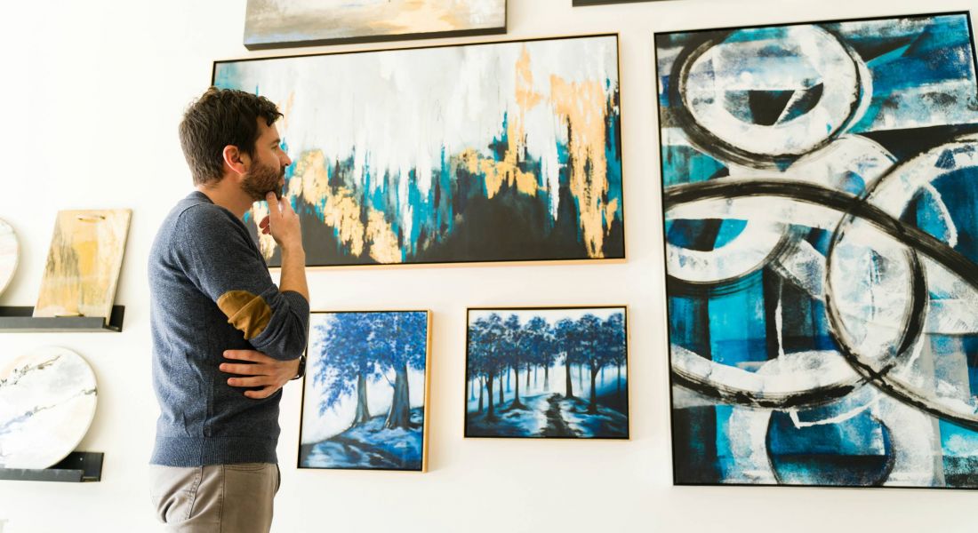Man looking at artwork on a gallery wall