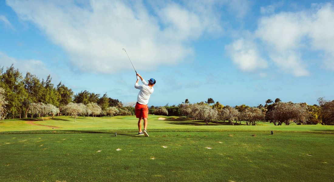 Person golfing on sunny day