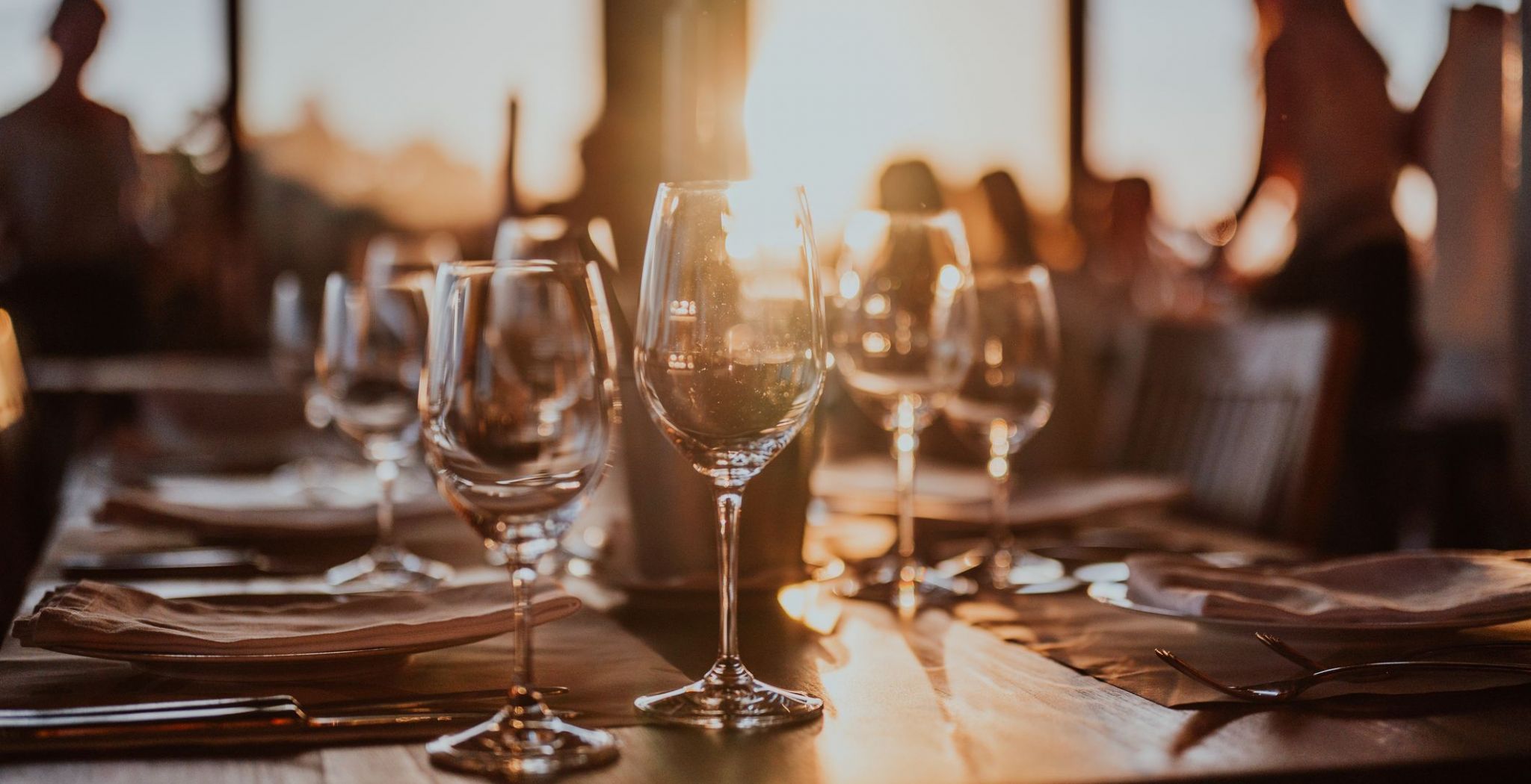 Wine glasses on a restaurant dining table at sunset